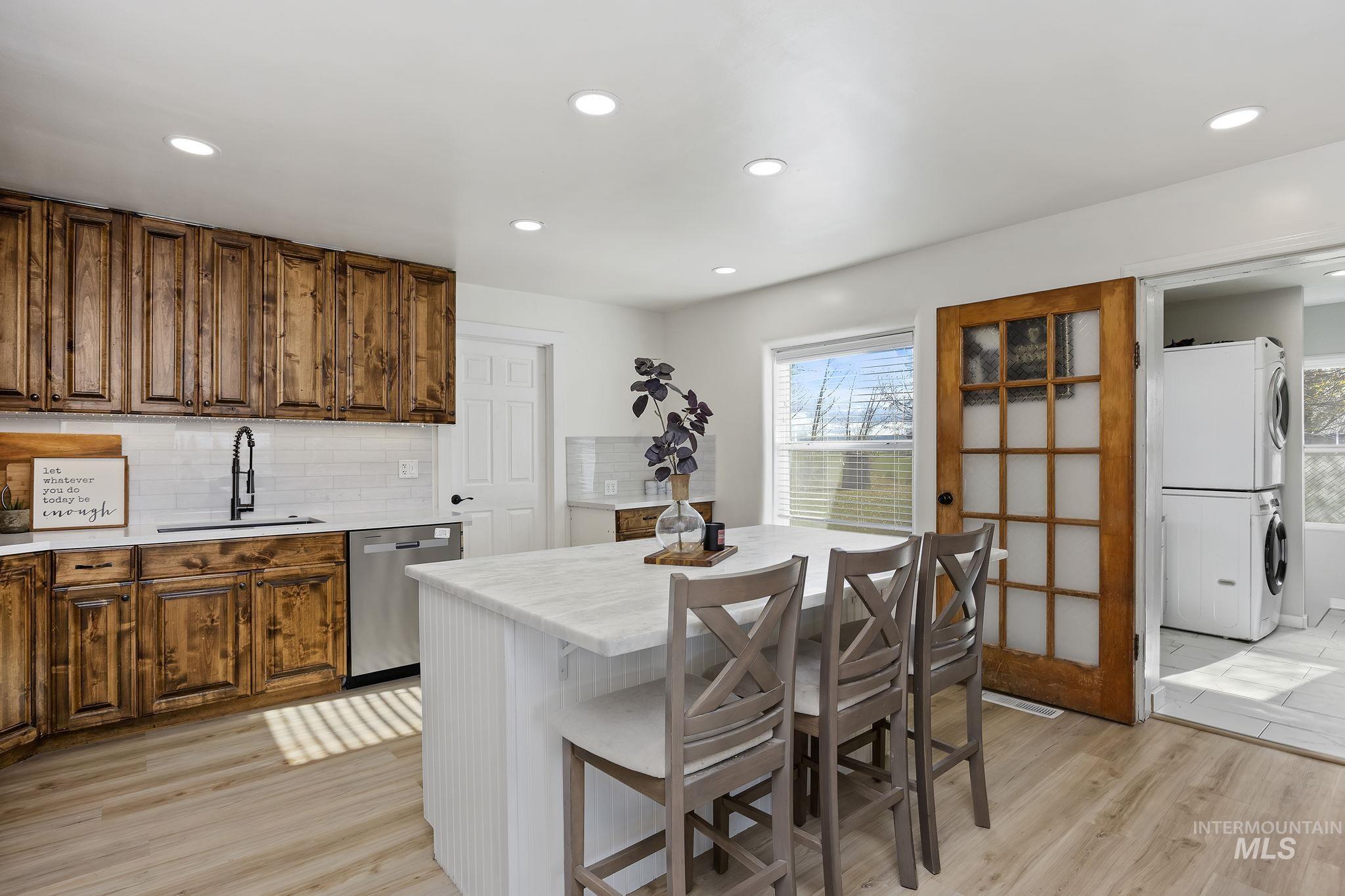 128 South 100 East Rupert, ID 83350 - Photo 11 of 44 Kitchen featuring decorative backsplash, a kitchen breakfast bar, light wood-type flooring, brown cabinetry, and recessed lighting