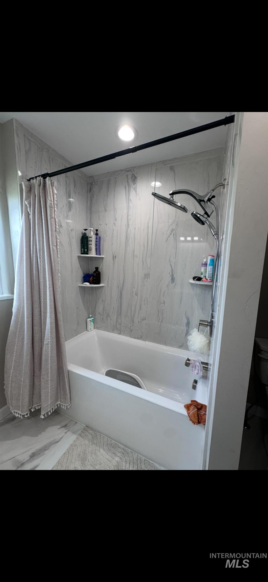 128 South 100 East Rupert, ID 83350 - Photo 22 of 44 Bathroom with shower / bath combo with shower curtain and marble look tile flooring