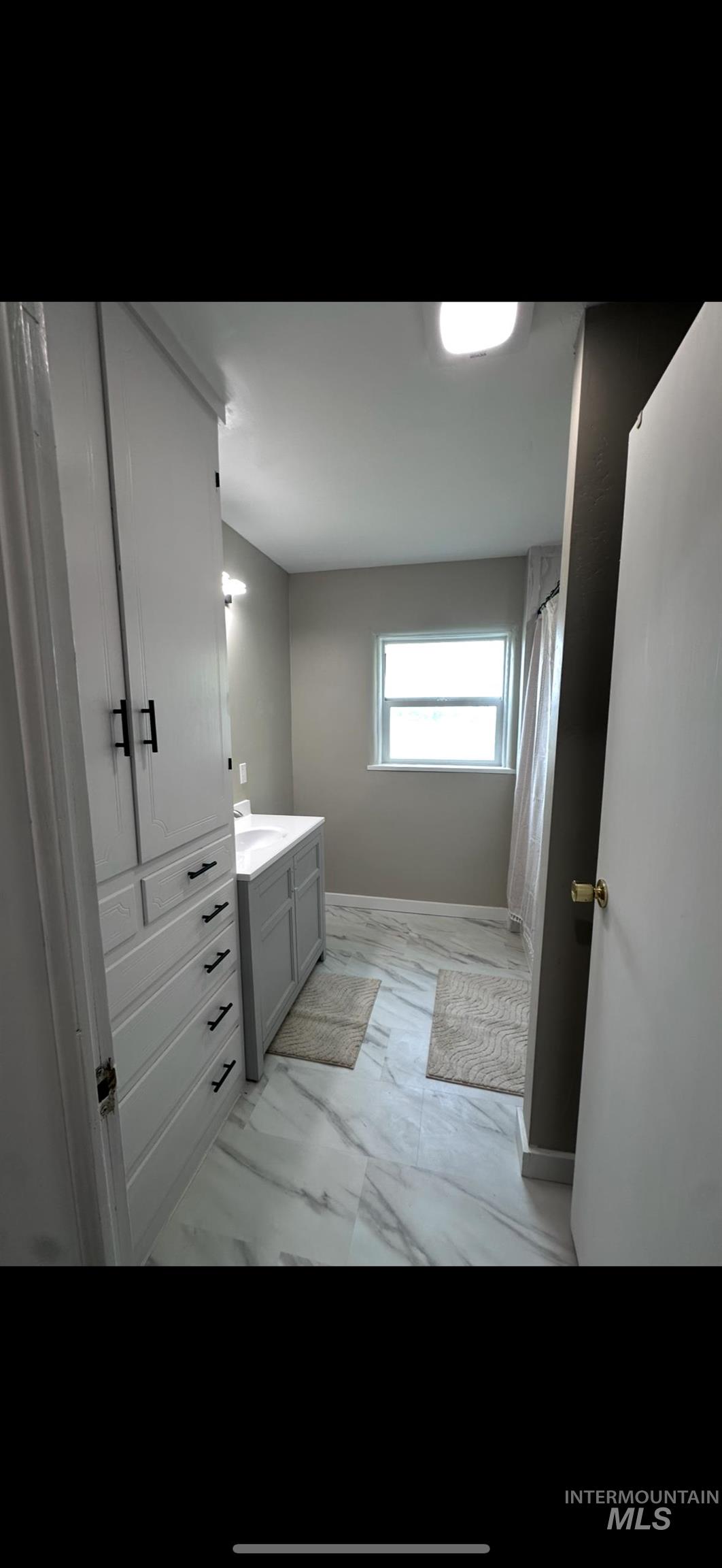 128 South 100 East Rupert, ID 83350 - Photo 23 of 44 Bathroom featuring vanity, a shower with shower curtain, and light marble finish floors