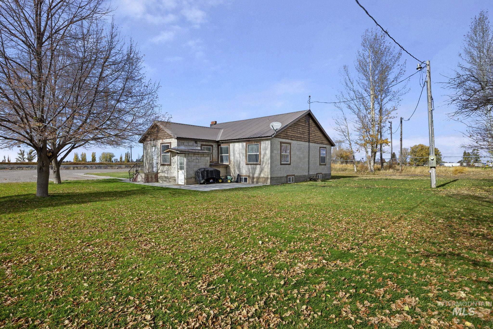 128 South 100 East Rupert, ID 83350 - Photo 3 of 44 View of home's exterior featuring a patio, a lawn, and a chimney