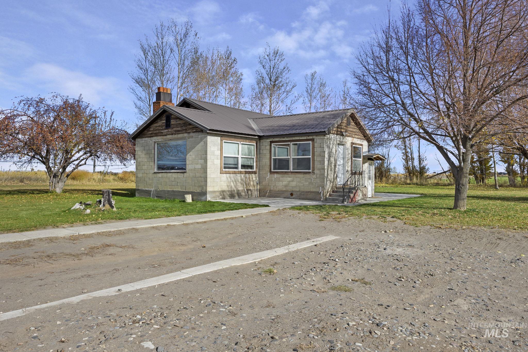 128 South 100 East Rupert, ID 83350 - Photo 4 of 44 View of side of property with a lawn, a chimney, a metal roof, and concrete block siding