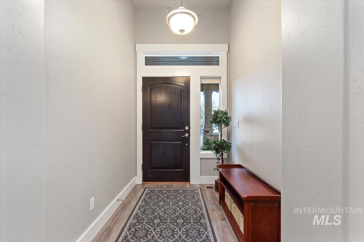 1447 West Arch Rock Street Meridian, ID 83646 - Photo 5 of 43 Doorway to outside with wood finished floors and a textured wall