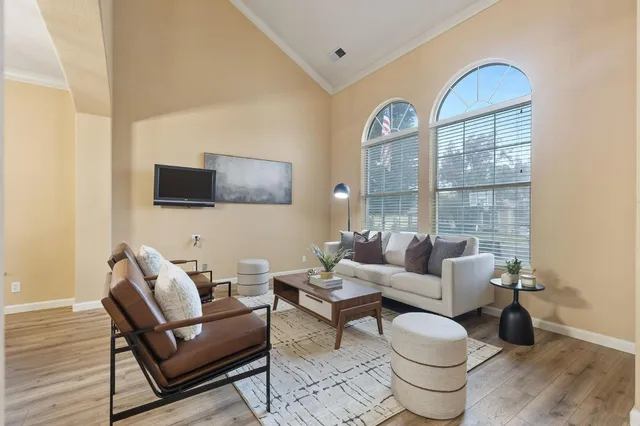 a living room with furniture a dining table and a chandelier