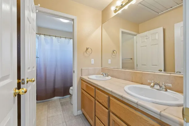 a spacious bedroom with a large bed and a chandelier