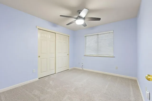 a bedroom with a large bed and ceiling fan