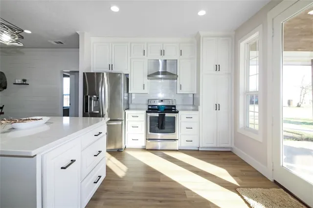 a kitchen with white cabinets and stainless steel appliances