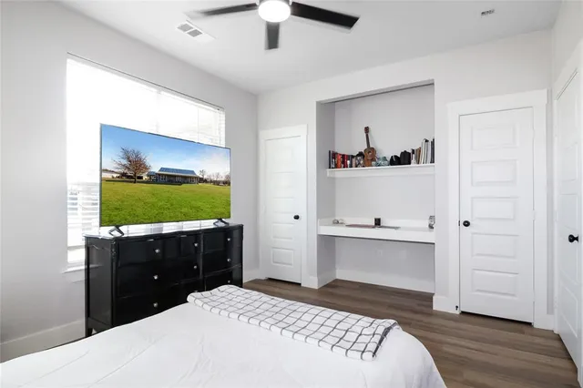 a bedroom with a bed and a flat tv screen on dresser