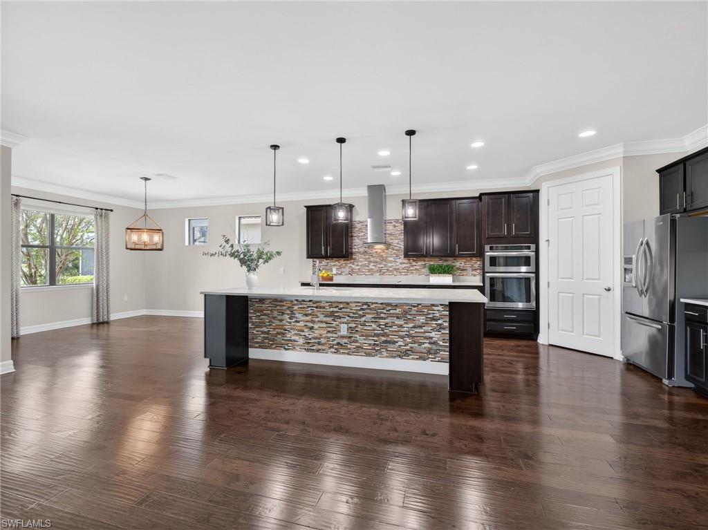 6124 Victory Drive Ave Maria, FL 34142 - Photo 16 of 50 a view of kitchen with stainless steel appliances kitchen island refrigerator stove and wooden floor