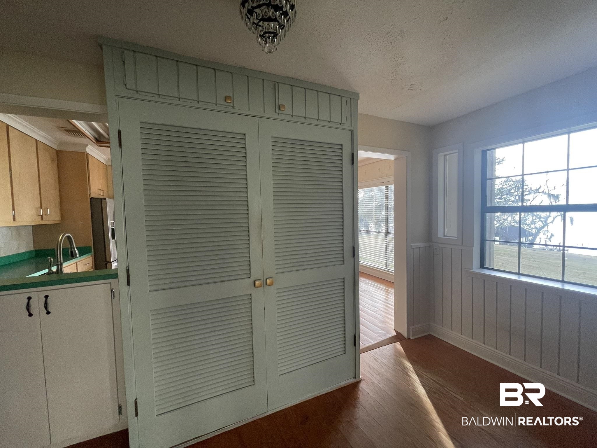 6621 Purvis Road Daphne, AL 36527 - Photo 31 of 59 Unfurnished dining area with dark wood-type flooring, a wainscoted wall, and a textured ceiling