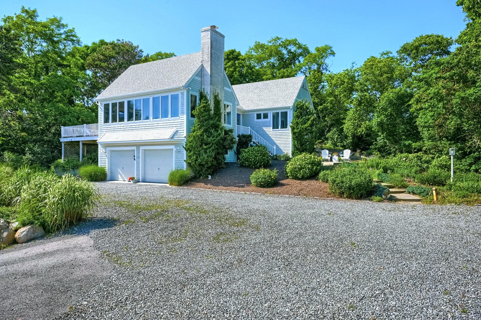 95 Chequessett Neck Road Wellfleet, MA 02667 - Photo 2 of 75 a front view of a house with a yard and garage