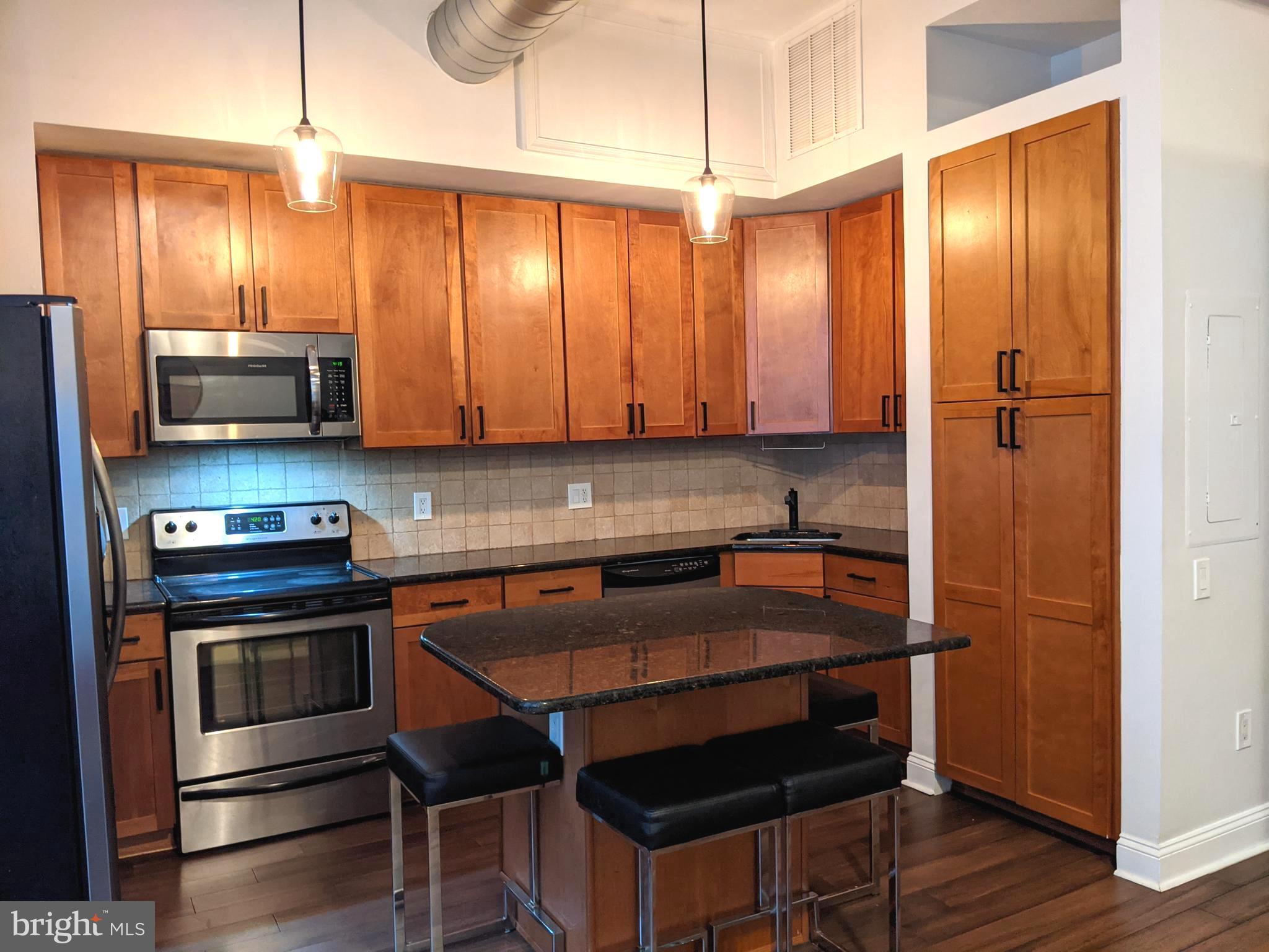 1100 South Broad Street, Unit 309B Philadelphia, PA 19146 - Photo 3 of 34 a kitchen with stainless steel appliances a stove a microwave and cabinets