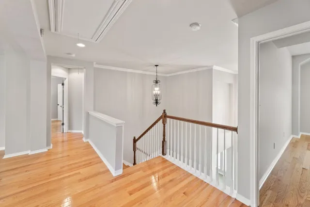 a view of a hallway with wooden floor and staircase