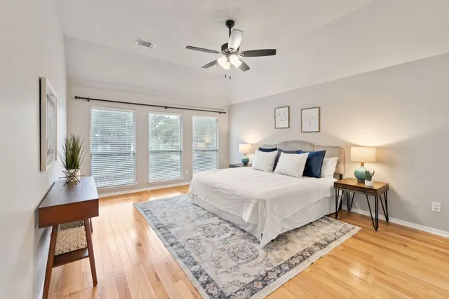 a spacious bedroom with a large bed and a chandelier