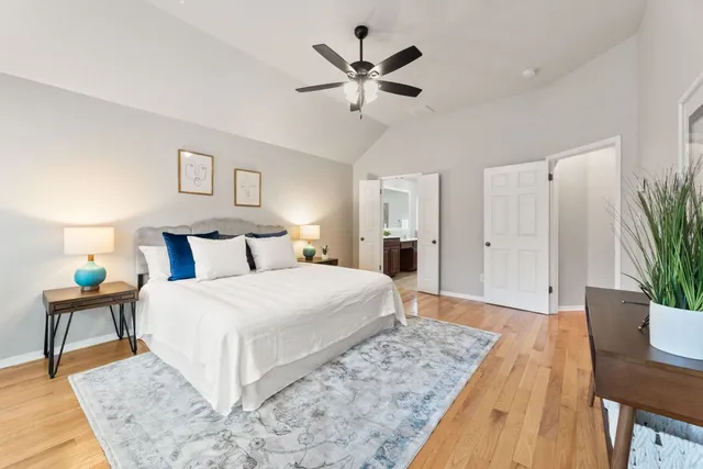 a bedroom with a large bed and a chandelier