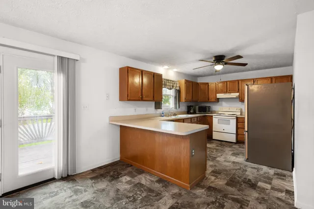 a kitchen with stainless steel appliances granite countertop a refrigerator a sink a stove and island