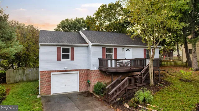 a view of a house with a wooden deck and a yard