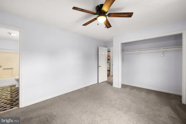 an empty room with closet and fan