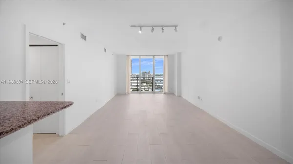 a view of a hallway to a livingroom with furniture