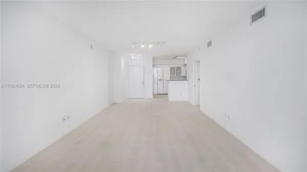 a view of a kitchen with refrigerator and a sink