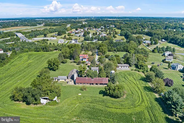an aerial view of residential houses with outdoor space and trees
