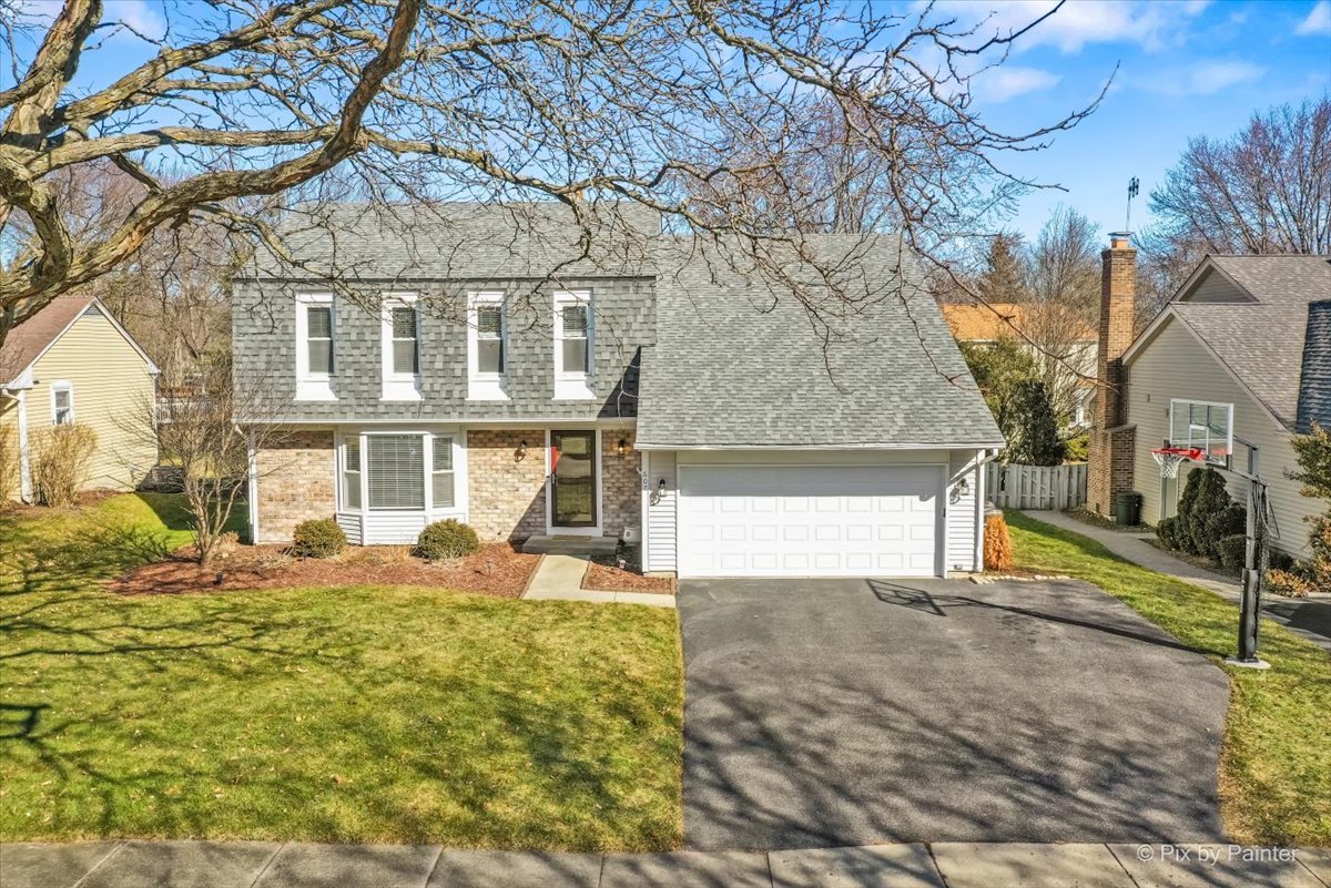 a front view of a house with a yard covered with snow