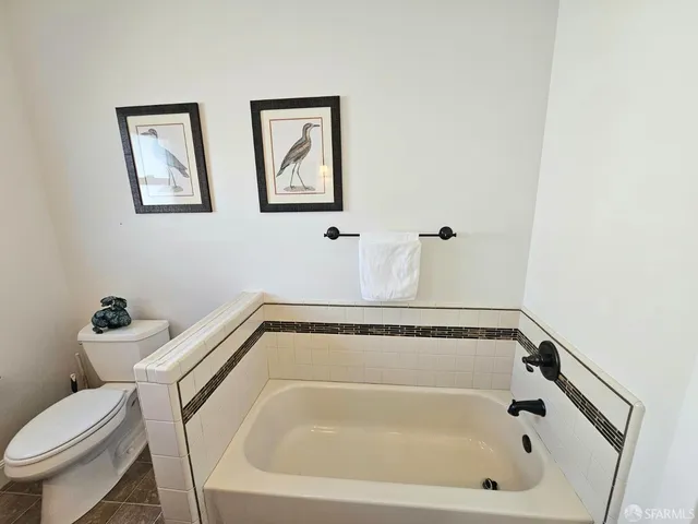 a bathroom with a tub and toilet