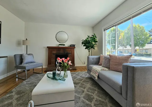 a living room with furniture fireplace and a large window