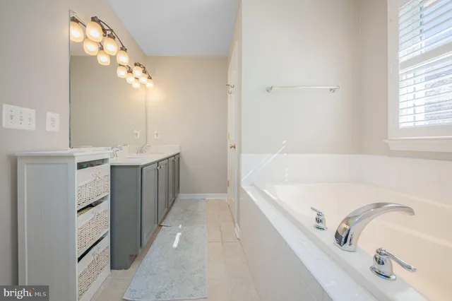 a bathroom with a tub sink and mirror