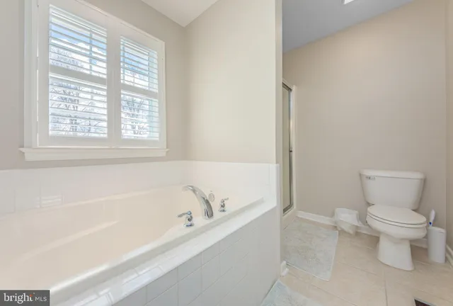 a white bath tub sitting next to a toilet