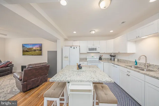 a kitchen with kitchen island sink stove and cabinets