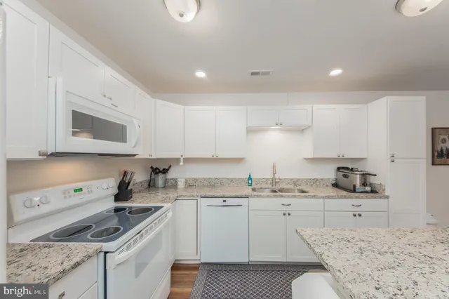 a kitchen with granite countertop a sink stove and cabinets
