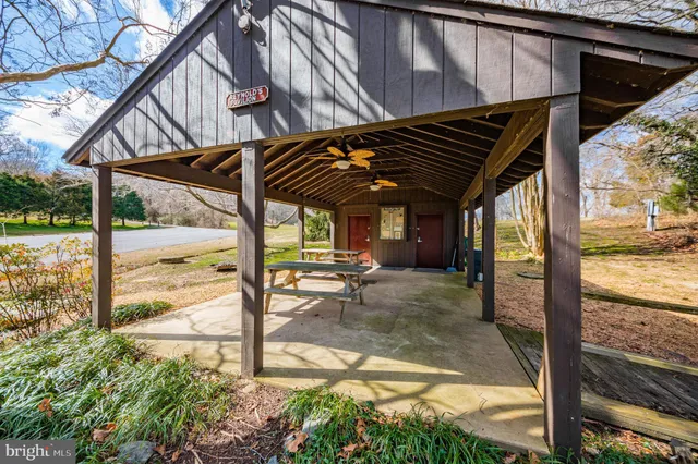 a view of a patio with table and chairs under an umbrella with a small yard