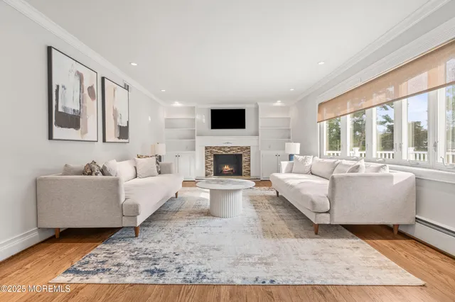 a living room with furniture a flat screen tv and a fireplace