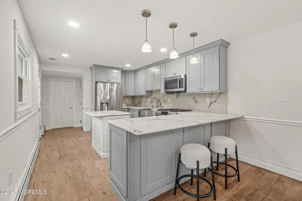 a kitchen with kitchen island a sink stainless steel appliances and white cabinets