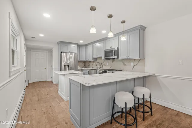 a kitchen with kitchen island a sink stainless steel appliances and white cabinets