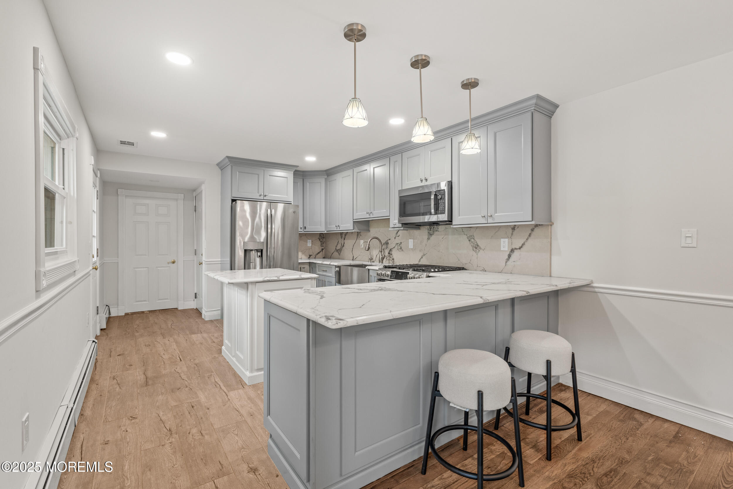 351 Hollywood Avenue Long Branch, NJ 07740 - Photo 8 of 34 a kitchen with kitchen island a sink stainless steel appliances and white cabinets