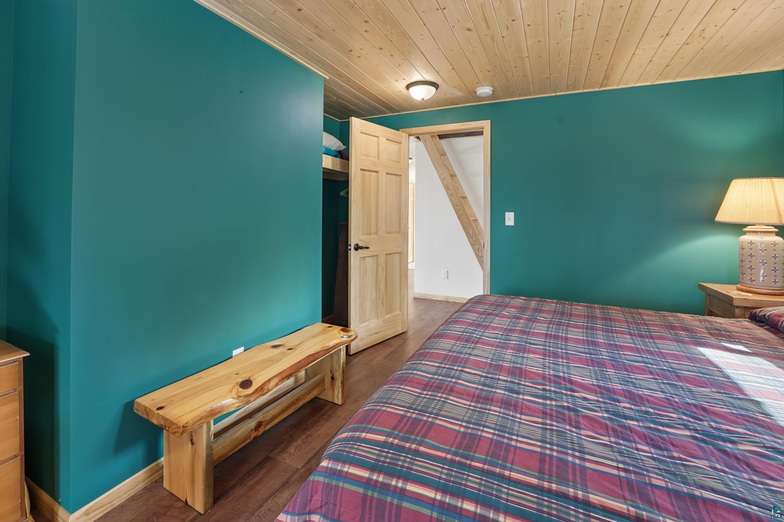 89095 West Romans Point Road Herbster, WI 54844 - Photo 19 of 30 Bedroom featuring teal walls and wood-finish flooring