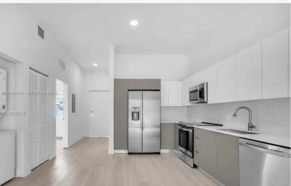a kitchen with a refrigerator sink and cabinets