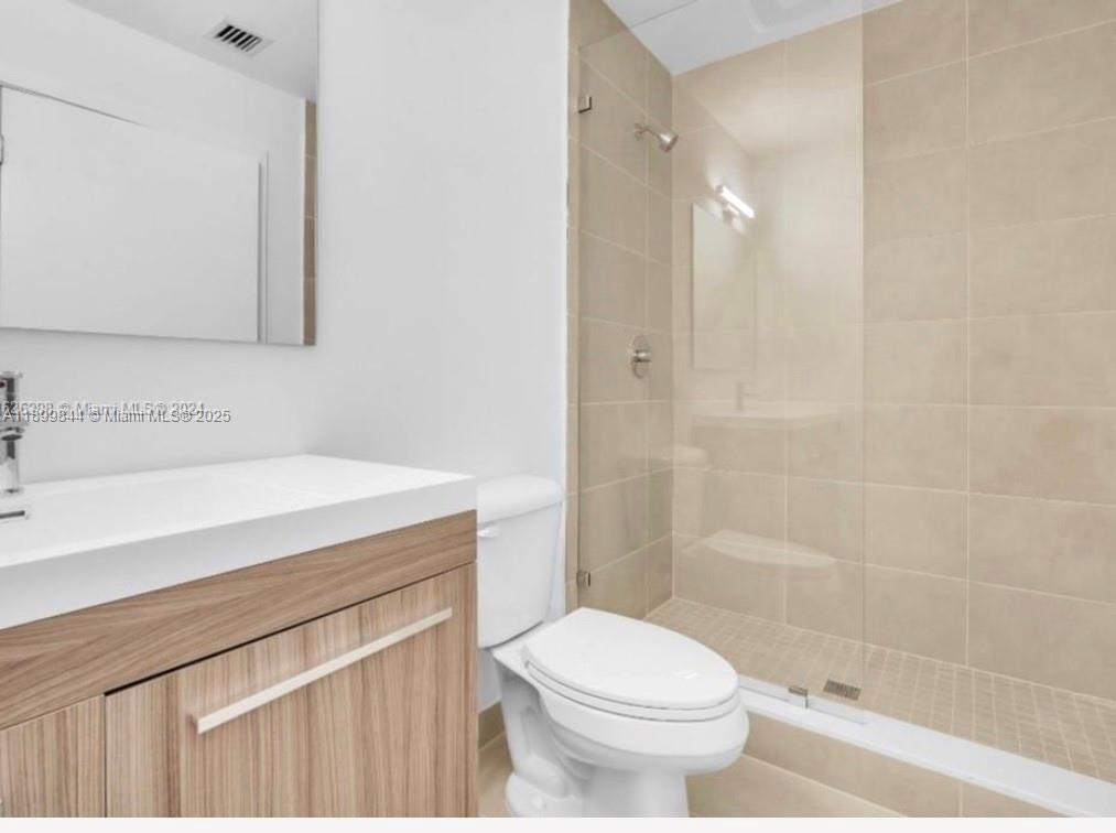 110 Foster Road, Unit 109B Hallandale Beach, FL 33009 - Photo 11 of 12 a bathroom with a sink a toilet and shower