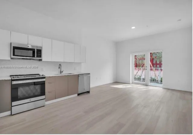 a kitchen with stainless steel appliances granite countertop a stove a sink and a microwave