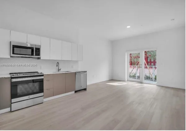 a kitchen with stainless steel appliances white cabinets and a stove top oven