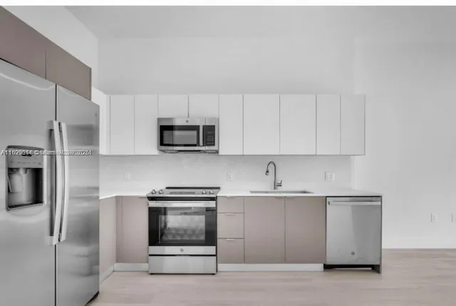 a kitchen with white cabinets and stainless steel appliances