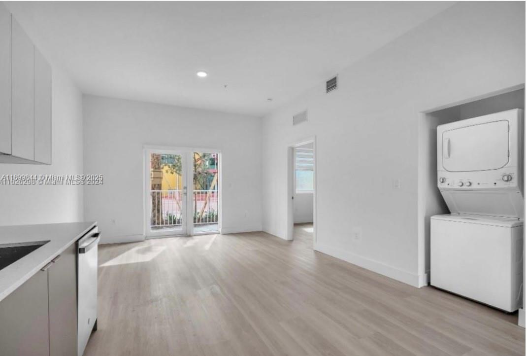 110 Foster Road, Unit 109B Hallandale Beach, FL 33009 - Photo 6 of 12 a view of an empty room with a window and wooden floor