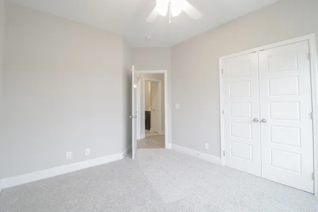 a view of an empty room and a chandelier fan