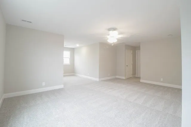 a view of an empty room with a ceiling fan