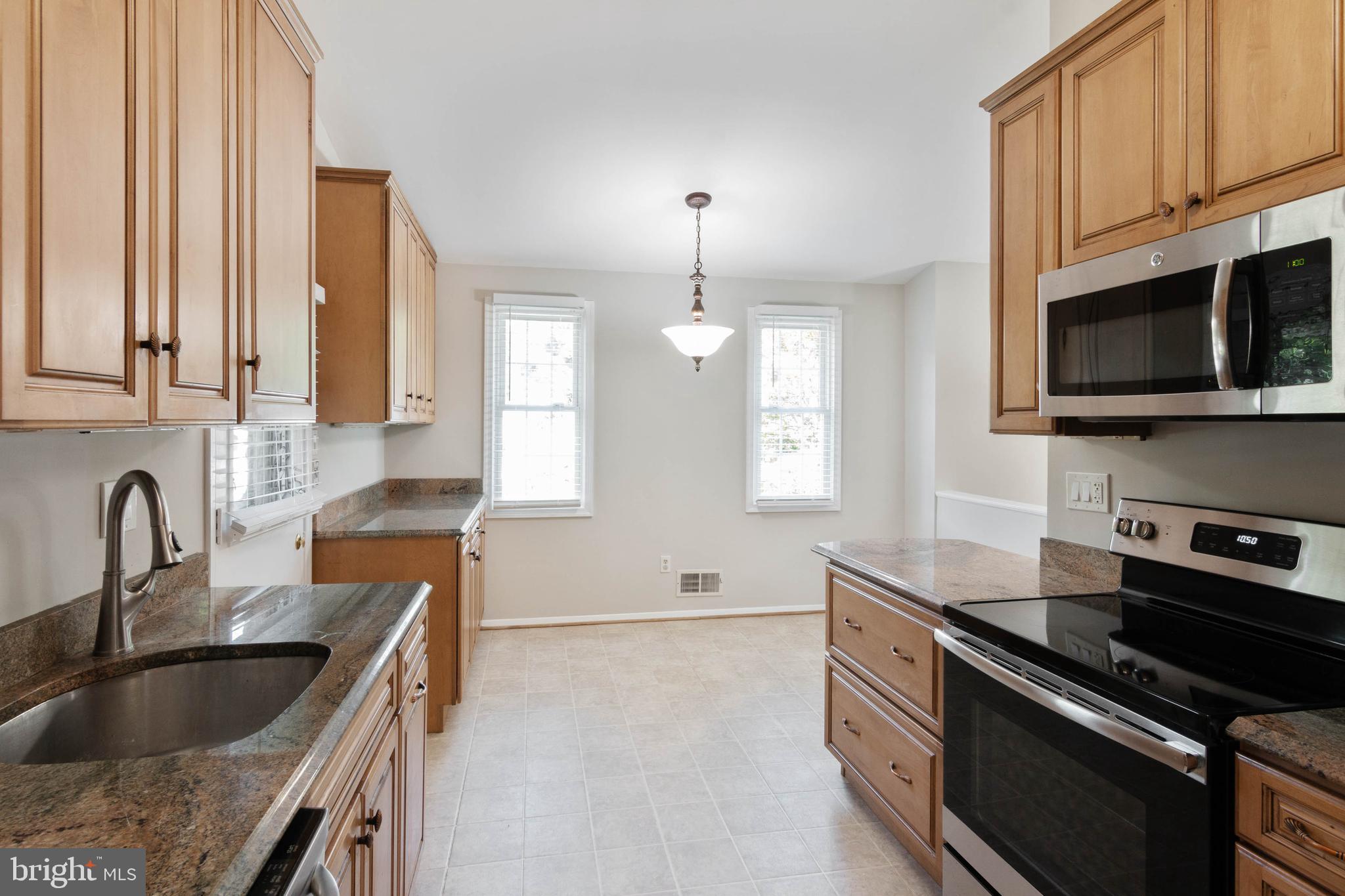 14217 Piccadilly Road Silver Spring, MD 20906 - Photo 3 of 38 a kitchen with granite countertop a stove sink and microwave