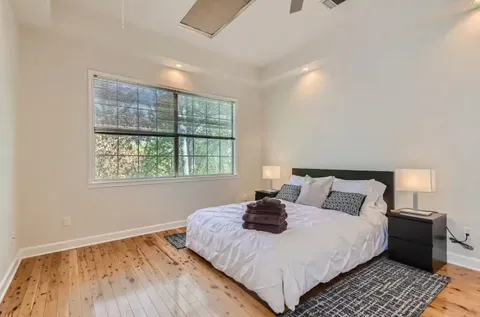 a bedroom with a bed and wooden floor