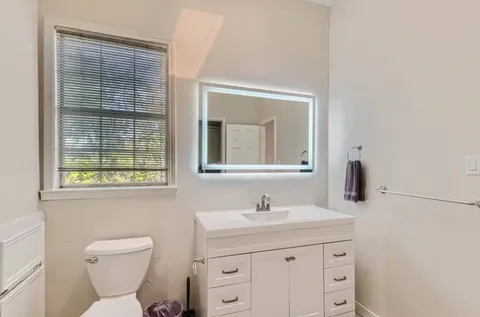 a bathroom with a toilet sink and mirror