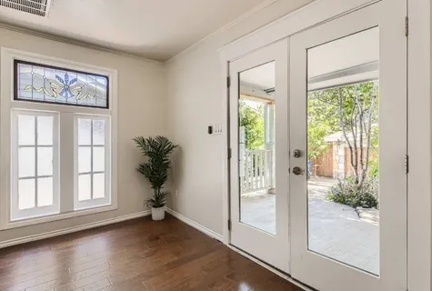 a view of empty room with wooden floor and floor to ceiling window