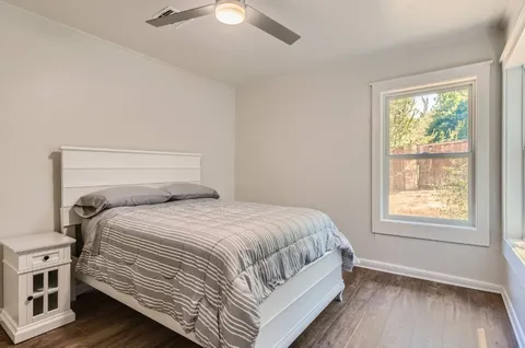 a bedroom with a bed next to a window